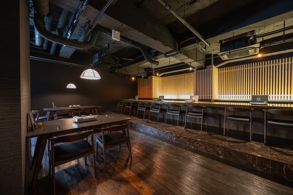 A calm interior featuring a single-plank wooden counter and wood-lattice lighting