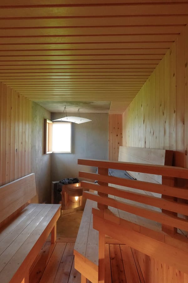 The sauna, which fits up to 8 guests at once — designed as a room for gathering rather than a solo retreat
