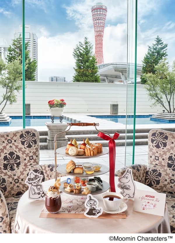 Soporte de tres niveles para el té de la tarde temático de Moomin con vistas a la Kobe Port Tower y una piscina de hotel al fondo