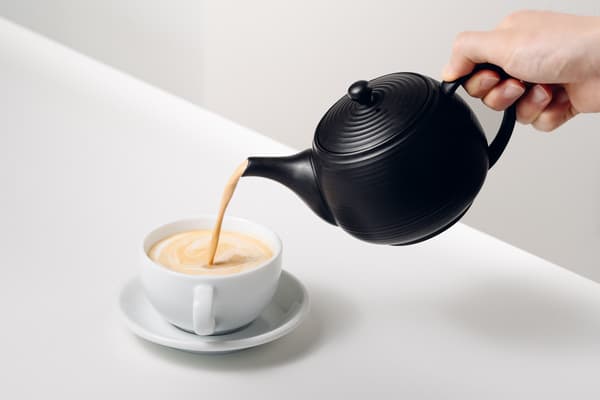 Menuangkan café au lait dari kyusu ke dalam cangkir