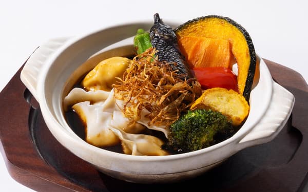 Lamb and gyojya ninniku mala soup curry gyoza served in a clay pot