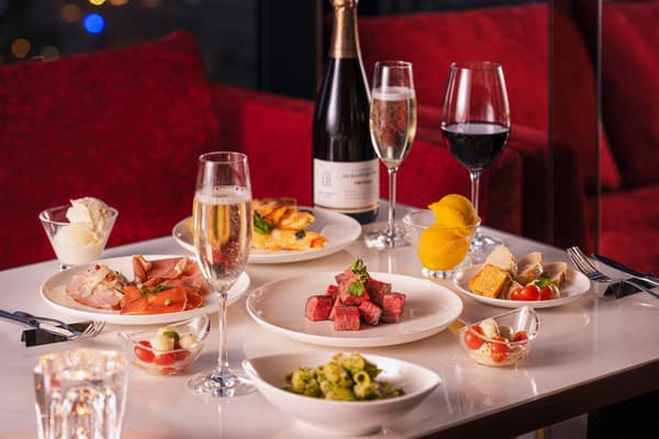 Platos del bufé de cena servidos con vino espumoso y vino tinto