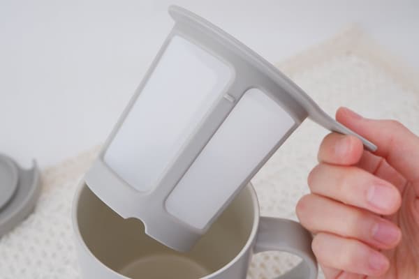 Digantung pada tepi mug melalui celah di dasar penyaring