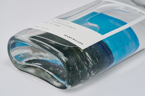 Bottle design showing forest visible through gin liquid