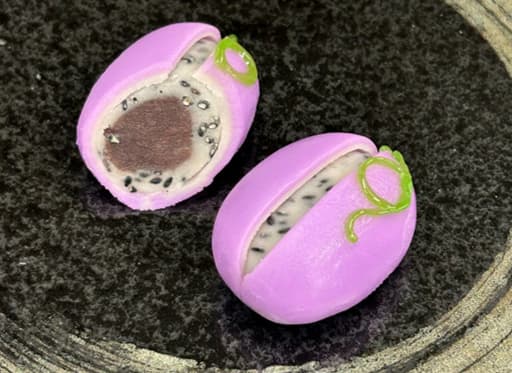 Wagashi Akebi no Sato dengan kulit ungu terbuka untuk menunjukkan nerikiri putih dan wijen hitam