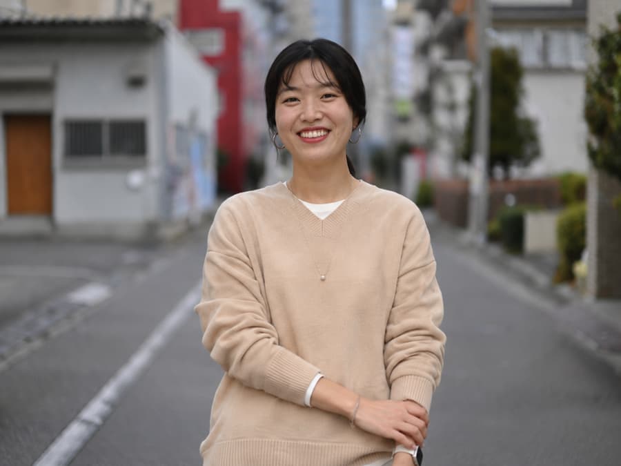Mari smiling on a quiet residential street
