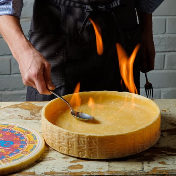 Rueda de queso utilizada para la pasta flameada con queso