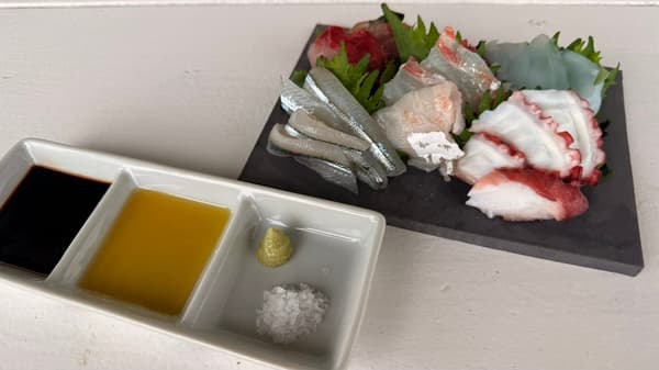 Plato de sashimi servido con sal de la isla de Awaji, wasabi, aceite de oliva personalizado de producción italiana y salsa de soja