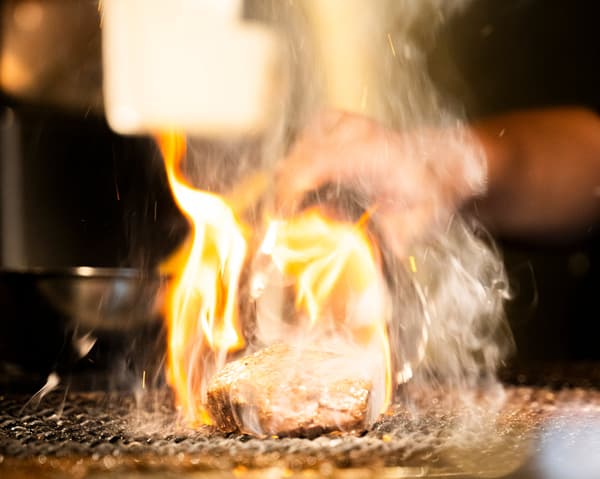 Daging wagyu sedang diiris di atas piring besi panas