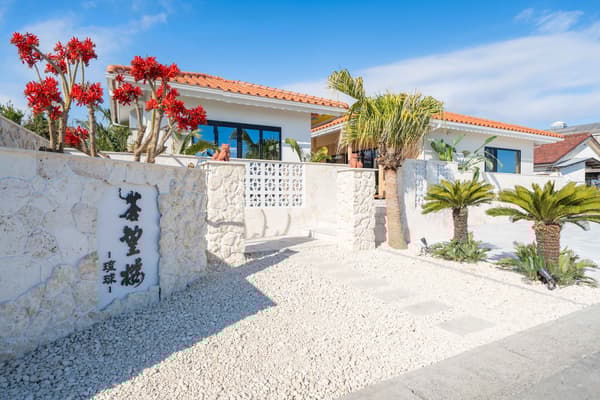 Exterior con piedra caliza de Ryukyu procedente de Okinawa y azulejos naranjas