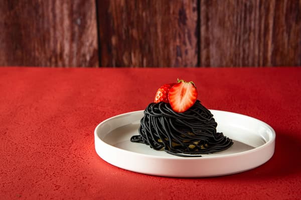 Primer plano del postre Mont Blanc negro azabache de fresa