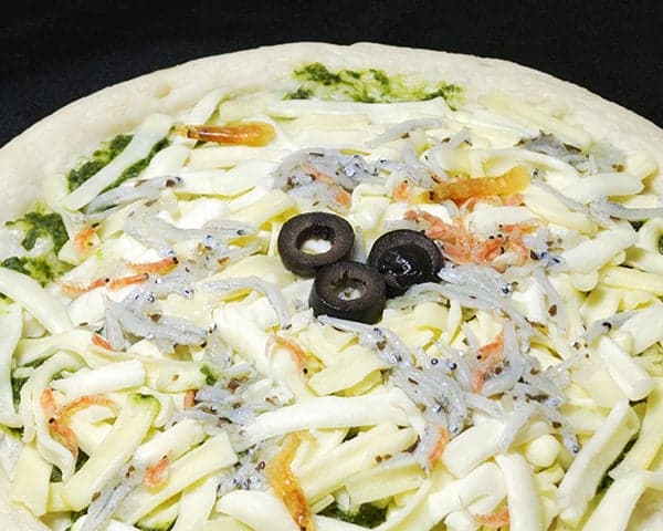 Pizza topped with whitebait and basil pesto