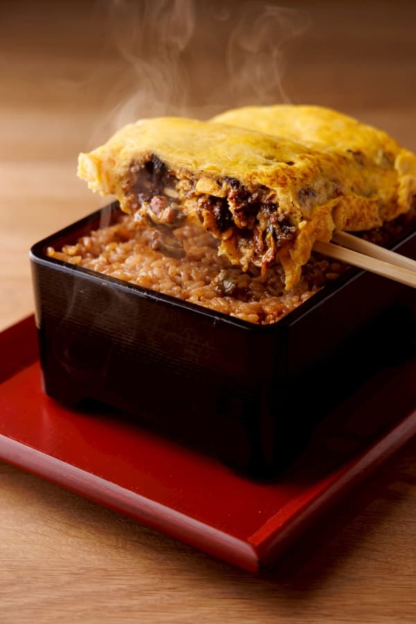 Umaki-ju (tortilla enrollada con tazón de arroz con anguila) generosamente cubierto con tortilla enrollada rellena de anguila