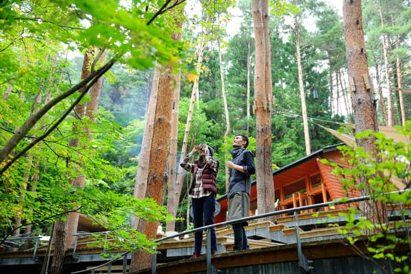 Huéspedes y un maestro de glamping saliendo a una ruta forestal por la mañana