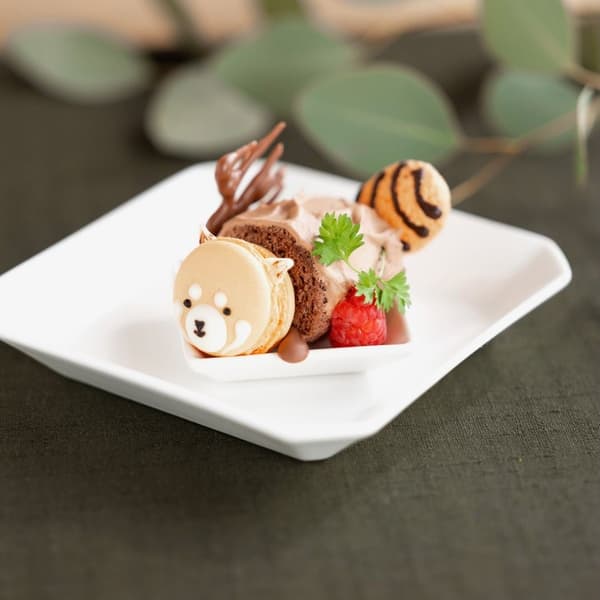 小熊猫马卡龙从木柴形状卷蛋糕中探出头来