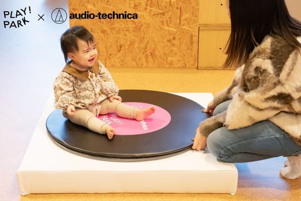 Niños interactuando con el tocadiscos gigante