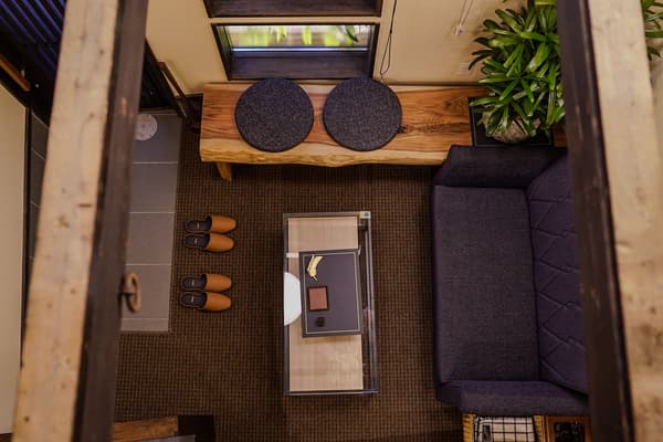 Brisa marina, el aroma de la madera, luz suave a través de las pantallas shoji, silbidos de trenes distantes