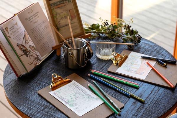 Huéspedes creando postales con lápices de colores en un lugar escénico alrededor del resort