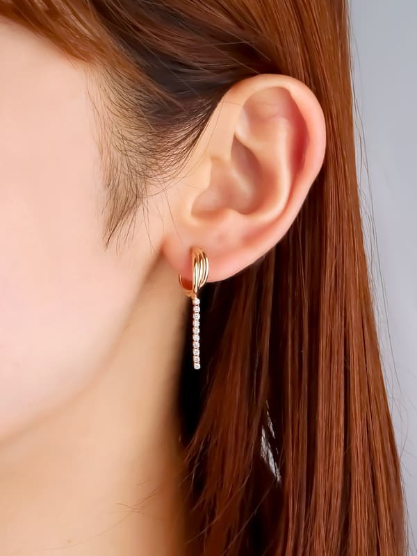 Vista lateral de los aretes de aro de línea cruzada con diamantes de laboratorio VARIÉLLE K10YG