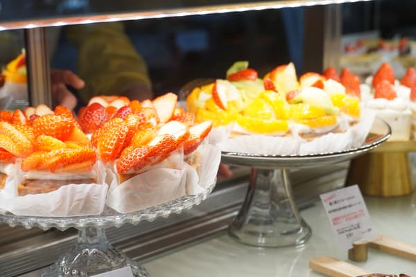 Una vitrina llena de tartaletas de frutas y tartaletas de fresas
