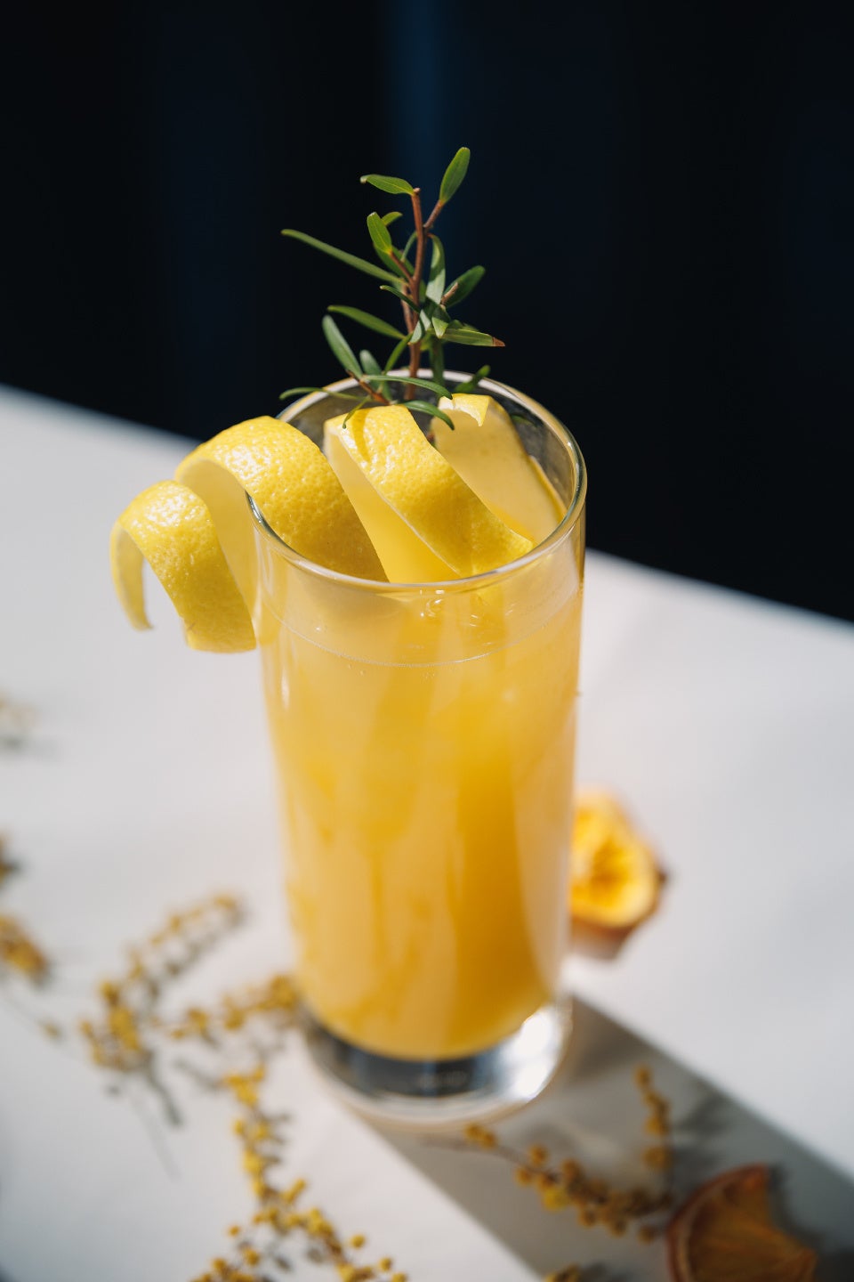 Koktail Mimosa Blanche dengan hiasan rosemary dalam gelas elegan