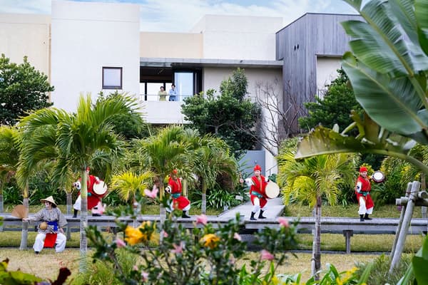 Performers carry the Eisa procession through the resort gardens