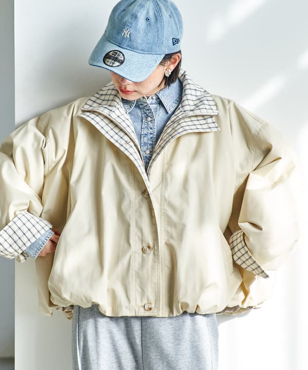 Vista frontal del abrigo abullonado con doble cuello a cuadros y bloques de color