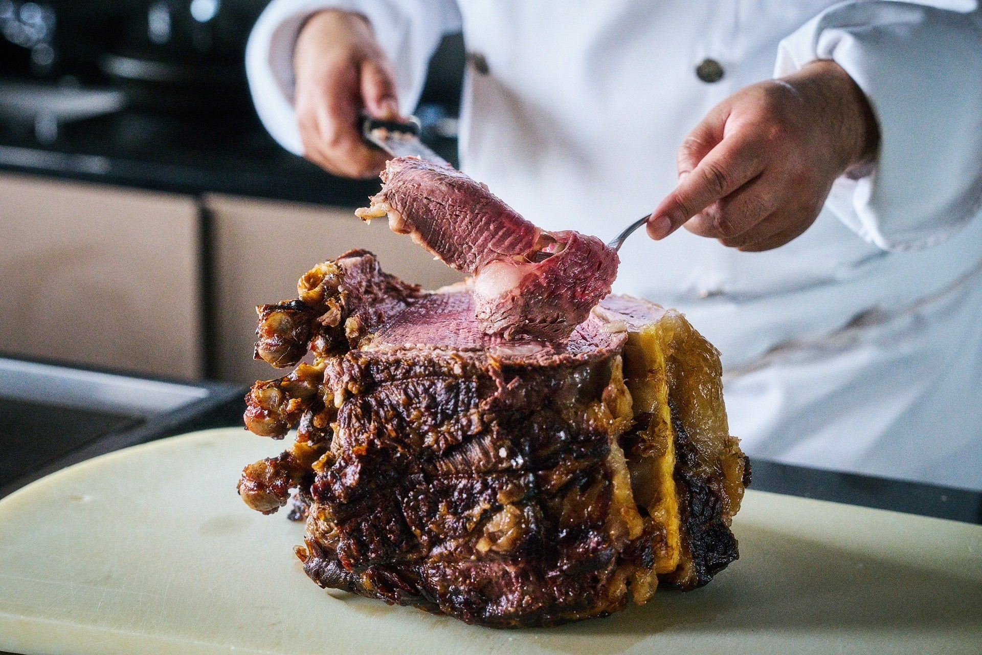 Tableside carving service of bone-in roast beef with jus de boeuf by Executive Chef Abiko
